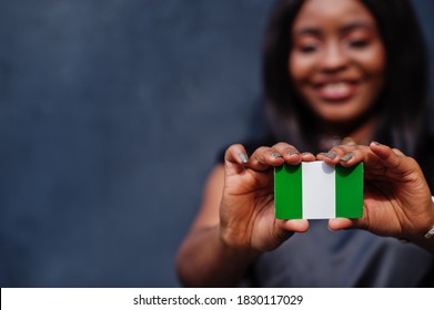 African Woman Hold Small Nigeria Flag In Hands.