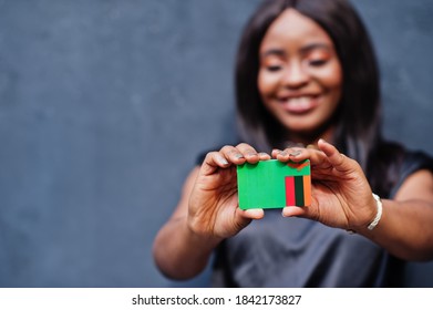 African Woman Hold Small Zambia Flag In Hands.