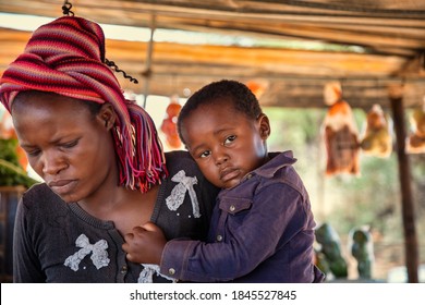 African Woman Holding Her Child,  Street Vendor With Entrepreneurial Spirit, Selling Vegetables On A Wooden Table