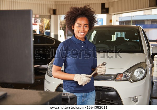 African woman is making a car mechatronics training\
in auto repair shop
