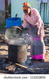 An african woman is making food the traditional way.
