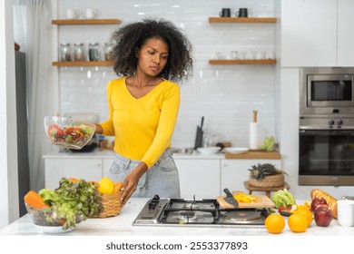 African woman preparing healthy food cooking vegetables and fruits in kitchen, healthy lifestyle, fresh ingredients meal preparation, nutrition, organic produce, culinary, kitchen activity at home - Powered by Shutterstock