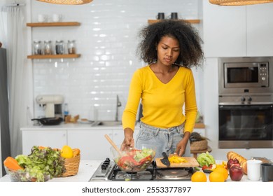 African woman preparing healthy food cooking vegetables and fruits in kitchen, healthy lifestyle, fresh ingredients meal preparation, nutrition, organic produce, culinary, kitchen activity at home - Powered by Shutterstock