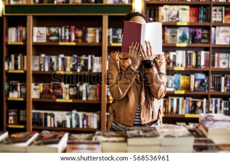 African woman reading a book at a bookstore.