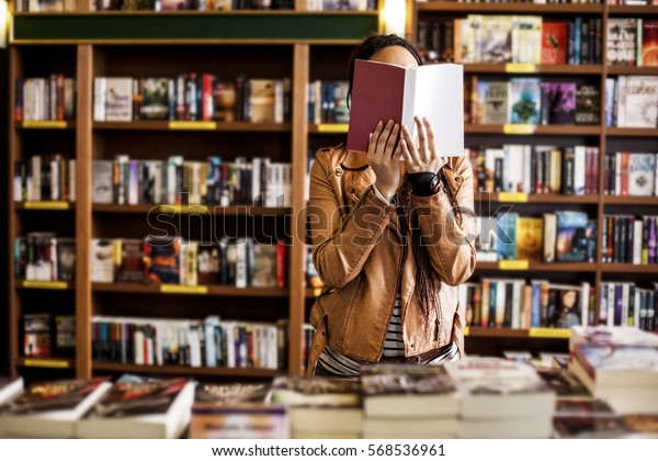 African woman\
reading a book at a\
bookstore.