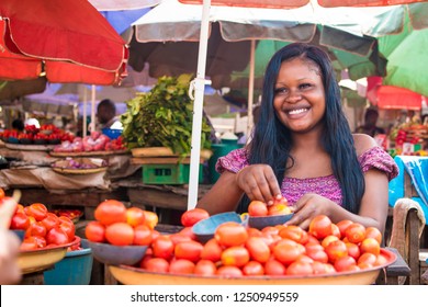 African Woman Selling Tomatoes In A Local African Market Smiling 