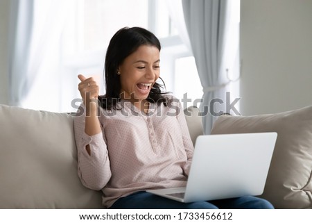 African woman sit on sofa hold notebook on lap feels happy showing thumbs up check bank application form loan approved, got new job, successfully pass entry exams, tax refund, 5g fast internet concept