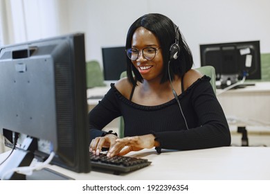 African Woman Sitting In Computer Science Class. Lady With Glasses. Female Student Sitting At The Computer.