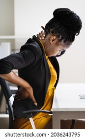 African Woman Sitting In Office Chair With Back Pain