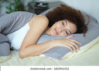 African Woman Sleeping In Her Bed At Night, She Is Resting With Eyes Closed. Cozy Bedtime. Lady Hugging Soft White Pillow. Lady Enjoys Fresh Soft Bedding Linen And Mattress In Bedroom