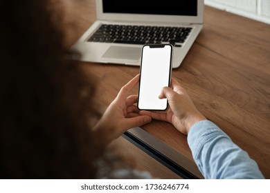 African Woman User Holding Smart Phone Mock Up Blank White Screen In Hand Using Mobile App At Home Office Order Work In App, Read News, Watch Video, Chatting Or Texting. Over Shoulder Closeup View.