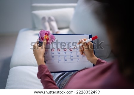 African Woman Using Menstrual Cycle Or Period Calendar
