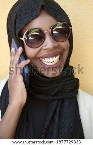 african woman using smartphone wearing traditional islamic clothes