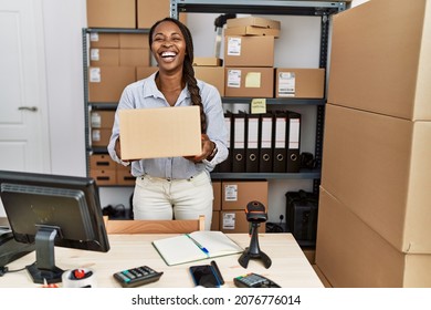 African Woman Working At Small Business Ecommerce Holding Box Smiling And Laughing Hard Out Loud Because Funny Crazy Joke. 