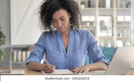 African Woman Writing on Paper at Work