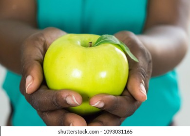 African Woman's hands with green apple