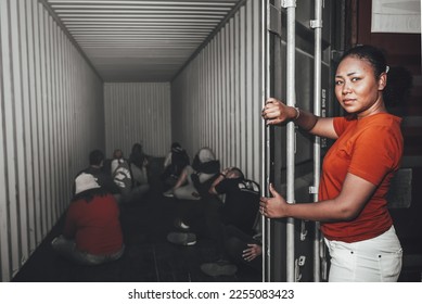 An African women Opening the door of a container, inside of which serveral people were sitting, to human trafficking and illegal immigration concept.