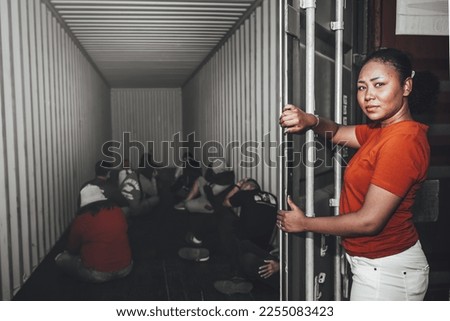 An African women Opening the door of a container, inside of which serveral people were sitting, to human trafficking and illegal immigration concept.