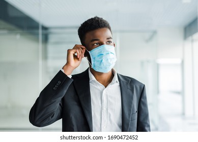 African young business man wearing a mouth protection to prevent getting sick at work in office