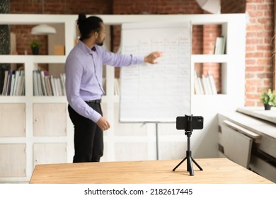 African Young Male Teacher Blogger Record Webinar Educational Class Use Cell Phone On Tripod, Explain Written Information Pointing On Flip Chart. Improve Language Skills, Tutoring, Education Concept