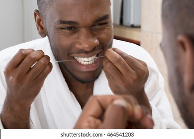 African Young Man Cleaning His Teeth In Front Of Mirror - Powered by Shutterstock