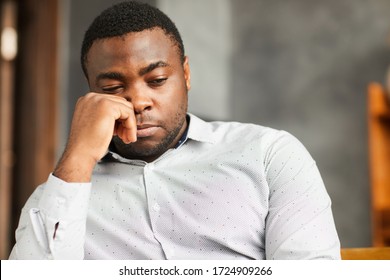 African Young Man Sitting With Sad Look Or Thinking About Something