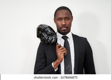 African Young Man Wearing Black Suit Taking Off Plastic Mask Revealing Face