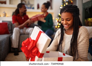 African Young Smiling Girl Opening Box With Christmas Gift