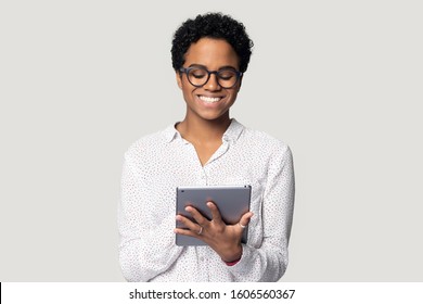 African Young Woman Holding Digital Tablet Isolated On Gray Background, Student Busy With Assignment Using Educational Websites Useful Applications, Freelancer Do Remote Distant Work On-line Concept