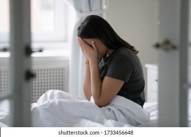 African Young Woman Wake Up Seated In Bed Crying. Concept Of Cheated Wife, Betrayal Of Husband And Divorce Break Up. Teenage Girl First Unrequited Love, Insomnia Sleep Disorder Health Problems Concept