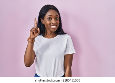 African Young Woman Wearing Casual White T Shirt Pointing Finger Up With Successful Idea. Exited And Happy. Number One. 