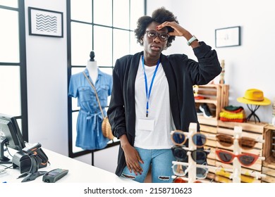 African young woman working as manager at retail boutique worried and stressed about a problem with hand on forehead, nervous and anxious for crisis 