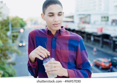 African-American boy at the center of a big city cocktail drink with fruit in a transparent cup. Outdoor Portrait. close up. - Shutterstock ID 496957030