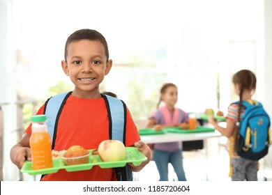 African-American boy holding tray with healthy food at school canteen