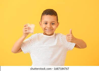 African-American boy with milk showing thumb-up on color background - Powered by Shutterstock