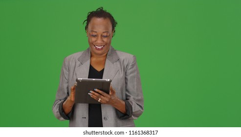 African-American business professional using pad device on green screen - Powered by Shutterstock