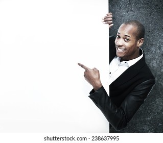 African-American Businessman near black wall background