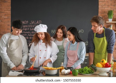 African-American chef and group of young people during cooking classes - Powered by Shutterstock