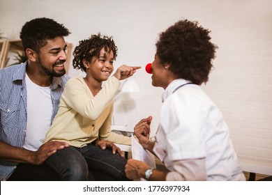 African-American clinician talking to little patient at hospital