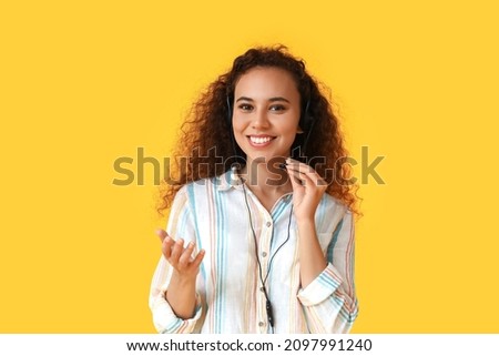 African-American consultant of call center in headset on yellow background