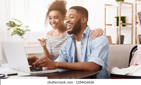 African-american couple searching tour online on laptop, preparing for holidays