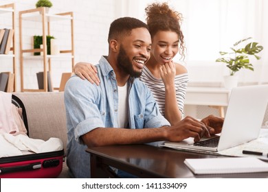 African-American Couple Searching Tour Online On Laptop, Preparing For Vacation