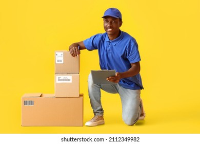 African-American delivery man with parcels on color background - Powered by Shutterstock