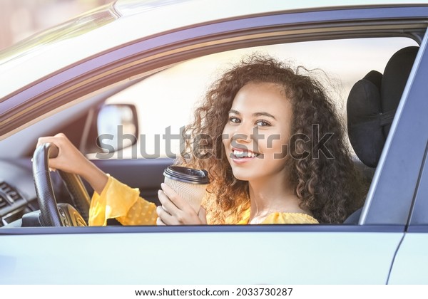 African-American female\
driver with coffee in\
car