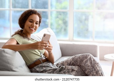 African-American female soldier with mobile phone at home - Powered by Shutterstock