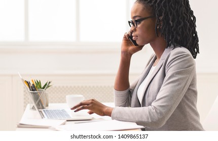African-American Freelancer Working In Modern Office, Talking On Phone, Side View - Shutterstock ID 1409865137