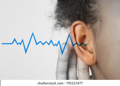 African-American Girl With Symptom Of Hearing Loss On Light Background