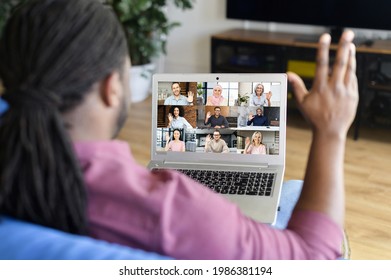 African-American guy taking a part in online webinar, video conference, waving hello and greeting group of diverse participants on the screen. Male employee involved morning meeting on the distance - Shutterstock ID 1986381194