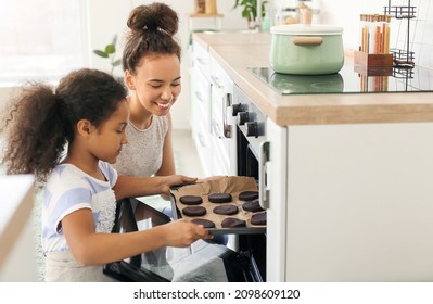 African-American little girl and her mother baking cookies in kitchen - Powered by Shutterstock