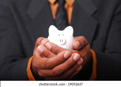 African-American male hands cradling a piggy bank.